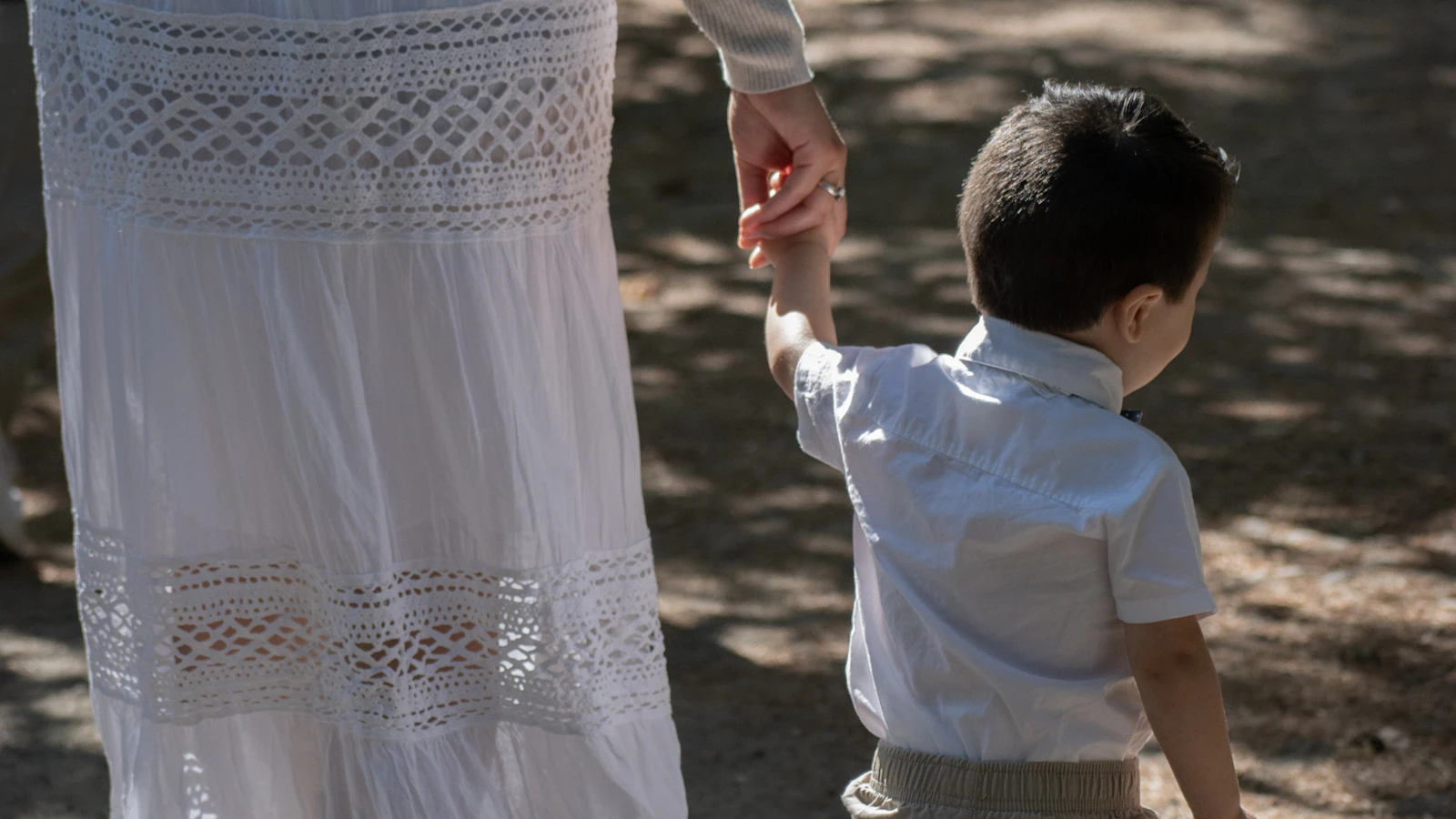 Een ouder en een kind wandelen hand in hand