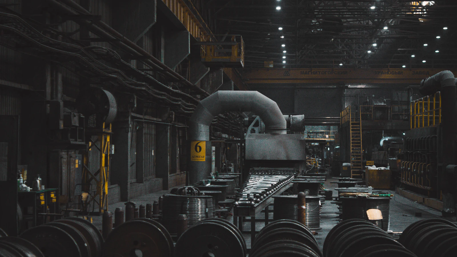 Een stille fabriekshal met machines en materiaal, zonder werknemers aan het werk